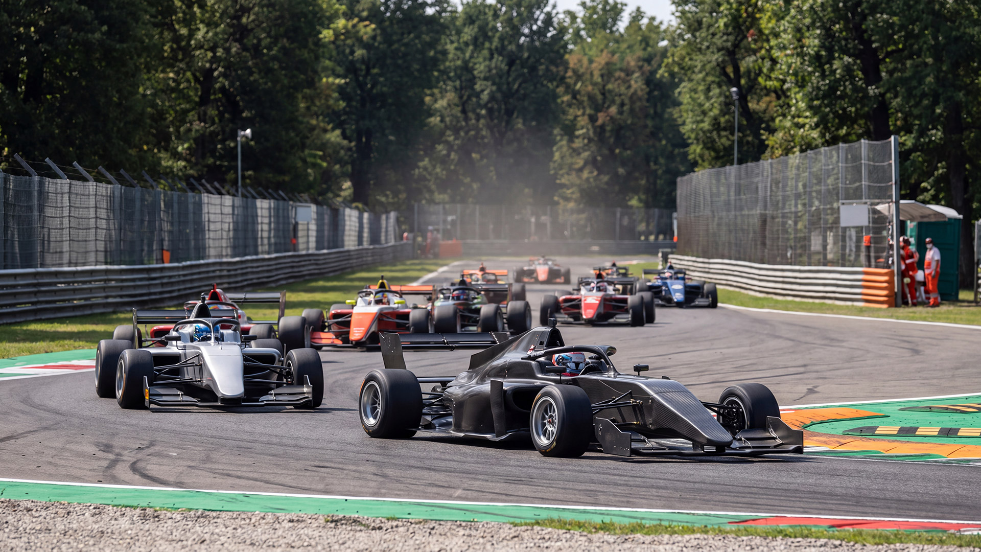 The Dark Side of Monza Circuit - Fatal Accidents and the Dangerous Years of Formula 1 6 Modern open-wheel racing cars competing through a corner at Monza Circuit